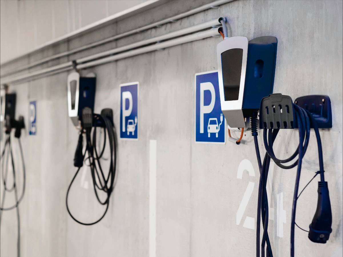Reihe von Wandladepunkten in einer Tiefgarage, jeder Stellplatz mit Parkschild gekennzeichnet