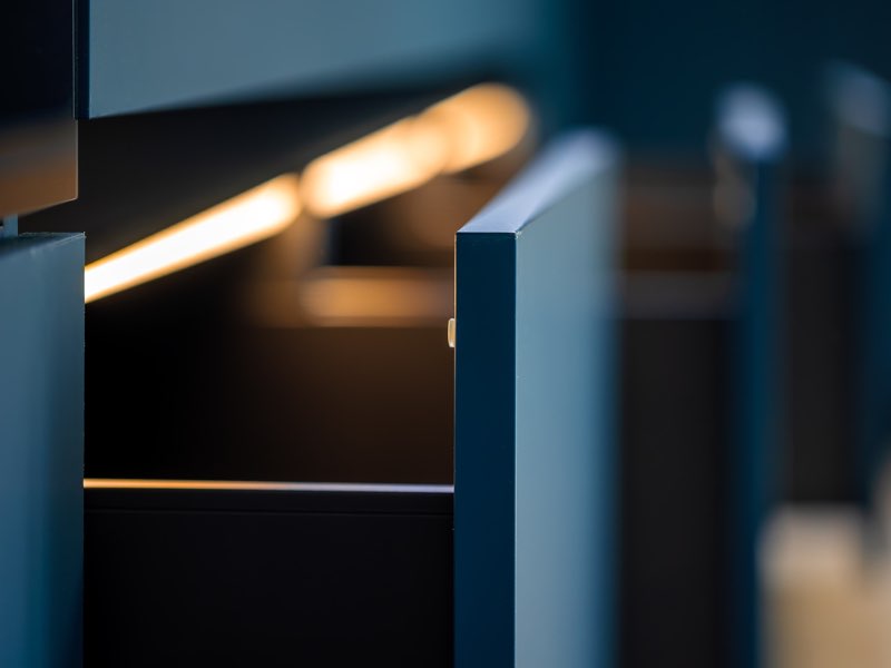 Warmes LED-Lichtband in einer dunkelblauen Möbelnische